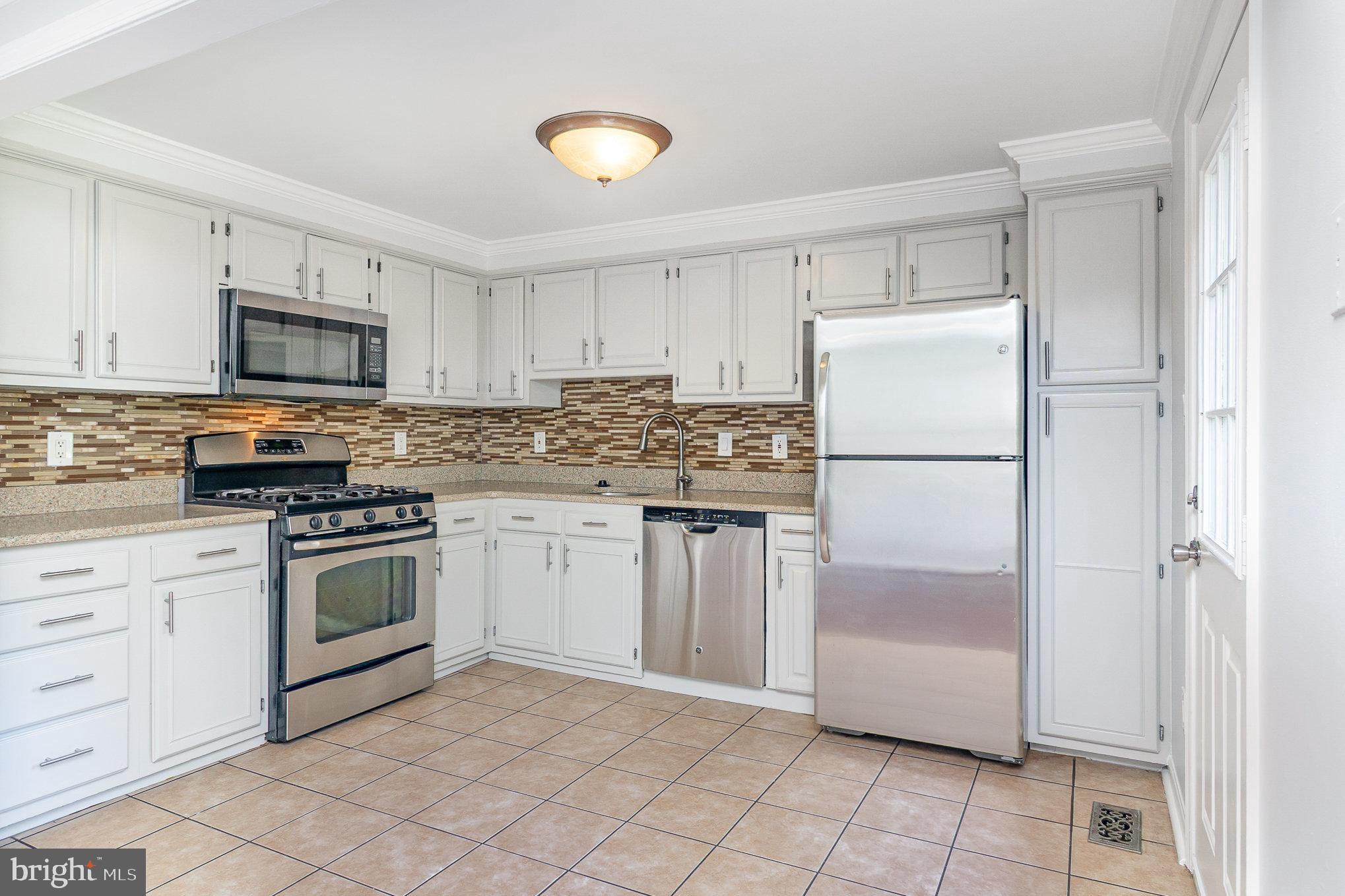 14888 Enterprise Lane Woodbridge, VA 22191 - Photo 7 of 25 a kitchen with white cabinets and white stainless steel appliances