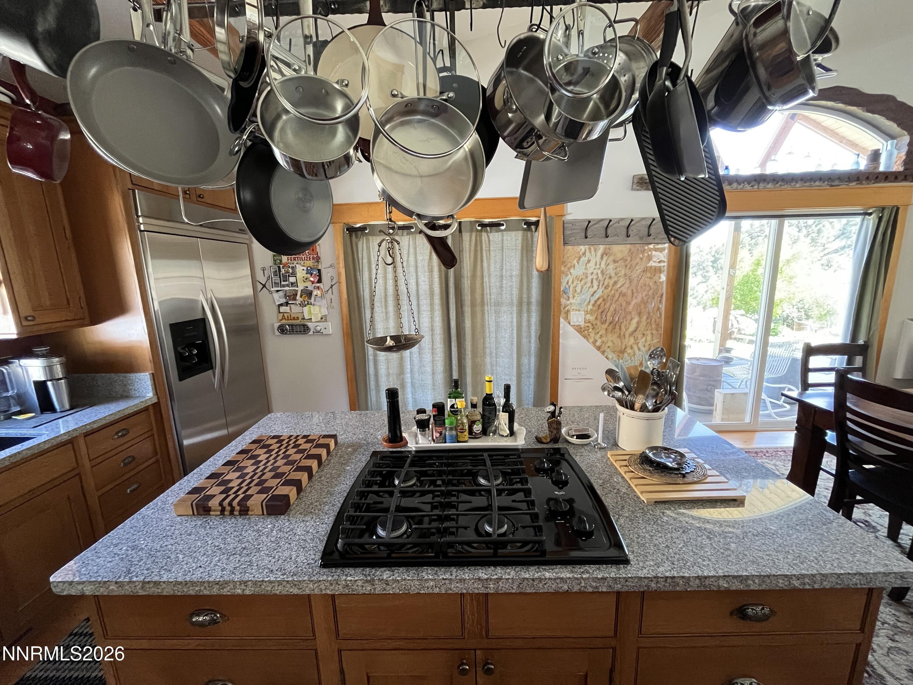 15 Wine Glass Way Kingston, NV 89310 - Photo 20 of 59 a kitchen with kitchen island granite countertop a stove a refrigerator a sink a dining table and chairs with wooden floor