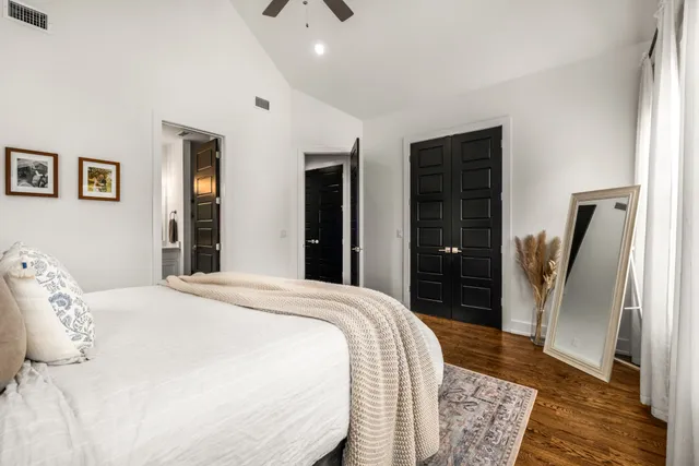 a spacious bedroom with a bed and a rug