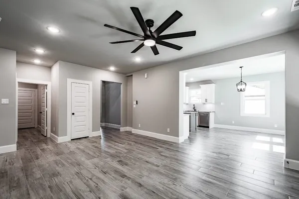 a view of a livingroom with a ceiling fan & a window