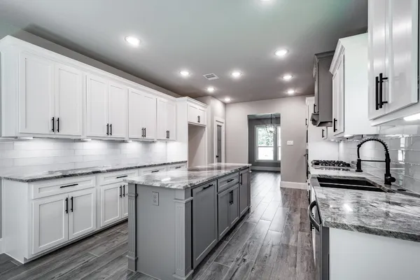 a kitchen with stainless steel appliances granite countertop a stove sink and cabinets