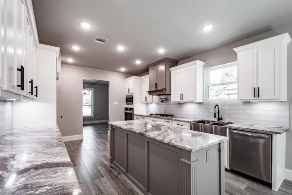 a kitchen with a sink stove cabinets and refrigerator