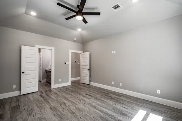 an empty room with closet and windows