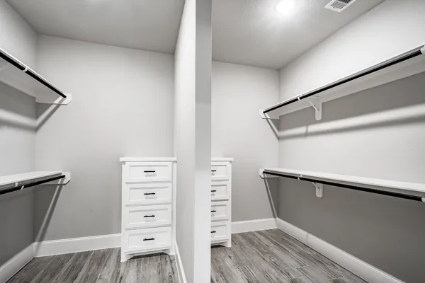 a view of walk in closet with clothes and shoes