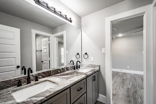 a bathroom with a granite countertop sink and a mirror