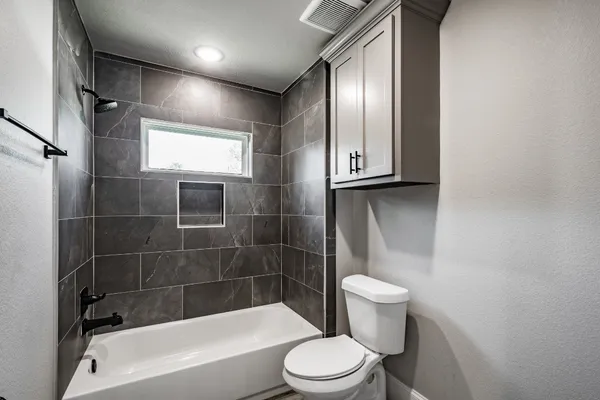 a bathroom with a toilet and a tub