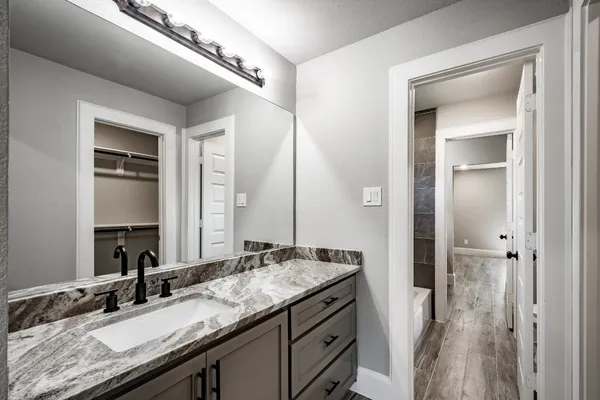 a bathroom with a granite countertop sink and a mirror