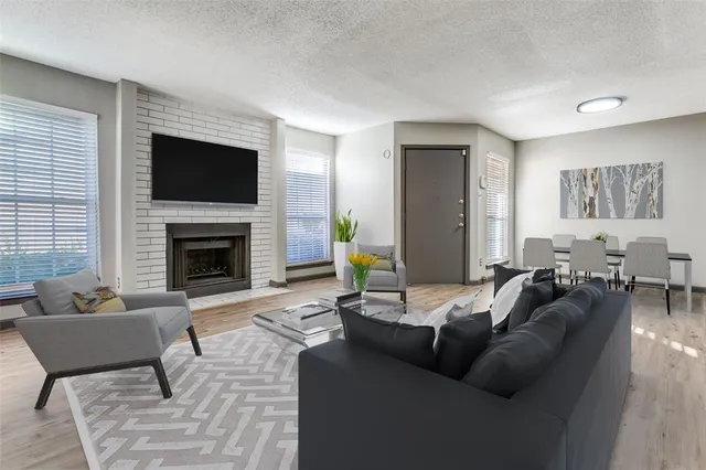 a living room with furniture a flat screen tv and a fireplace