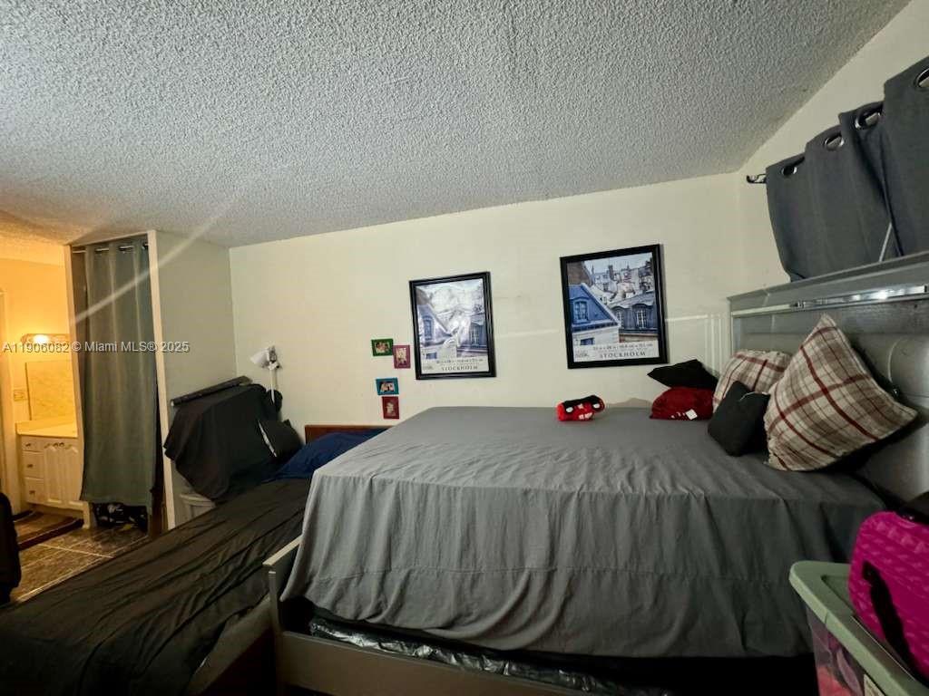 3730 Inverrary Drive, Unit 3B Lauderhill, FL 33319 - Photo 36 of 53 a bedroom with a bed and wooden floor