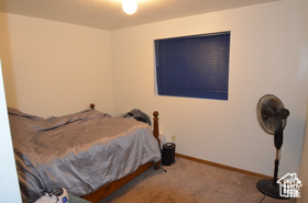 6874 South 595 East Midvale, UT 84047 - Photo 12 of 16 Bedroom featuring carpet flooring and baseboards