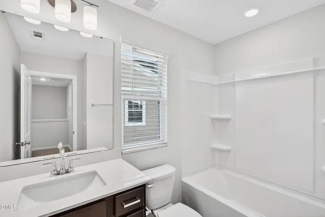 a bathroom with a sink toilet vanity and bathtub