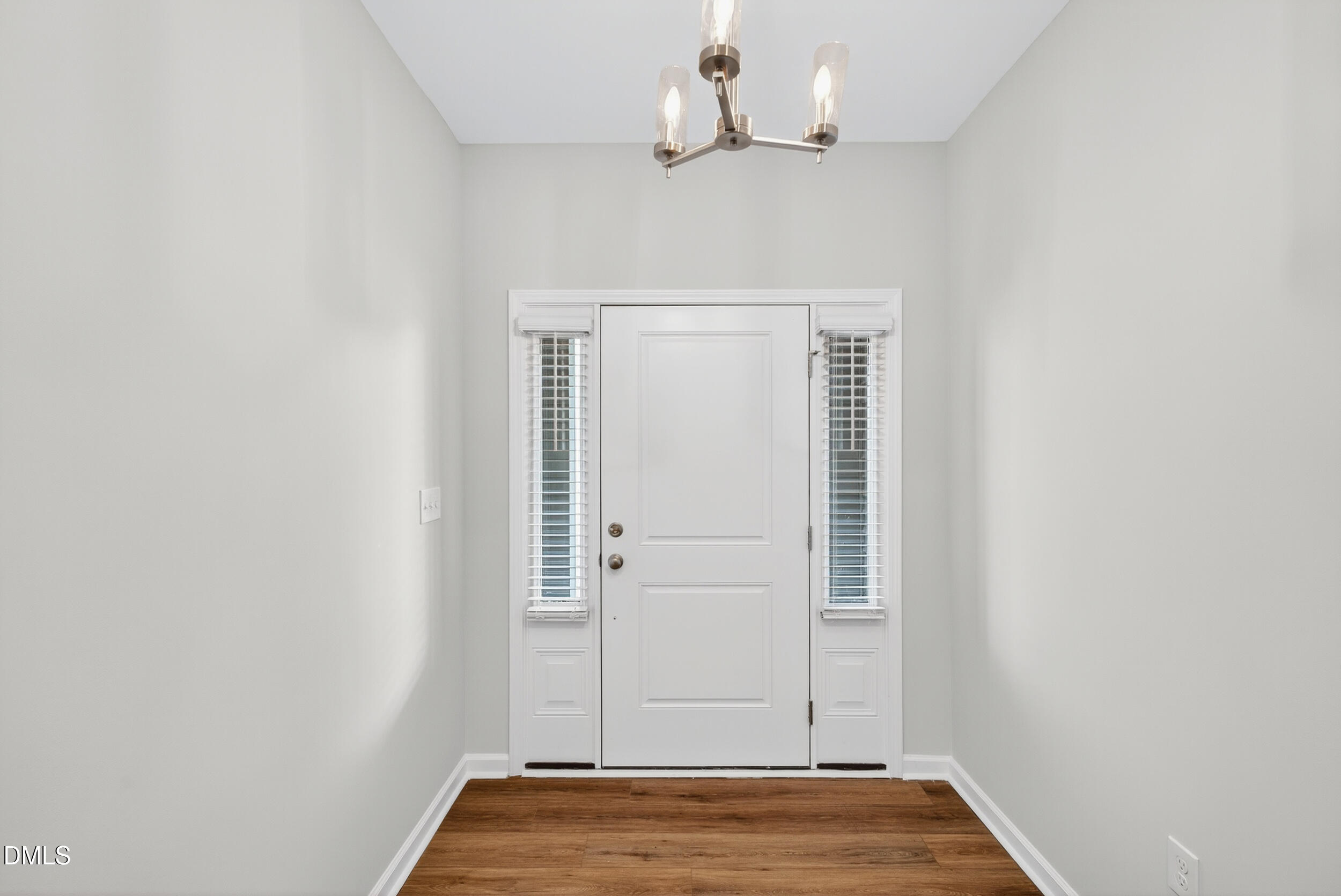 331 Chesapeake Commons Street Garner, NC 27529 - Photo 4 of 20 an empty room with wooden floor cabinet and hallway