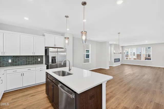 a kitchen with a sink a center island stainless steel appliances and cabinets