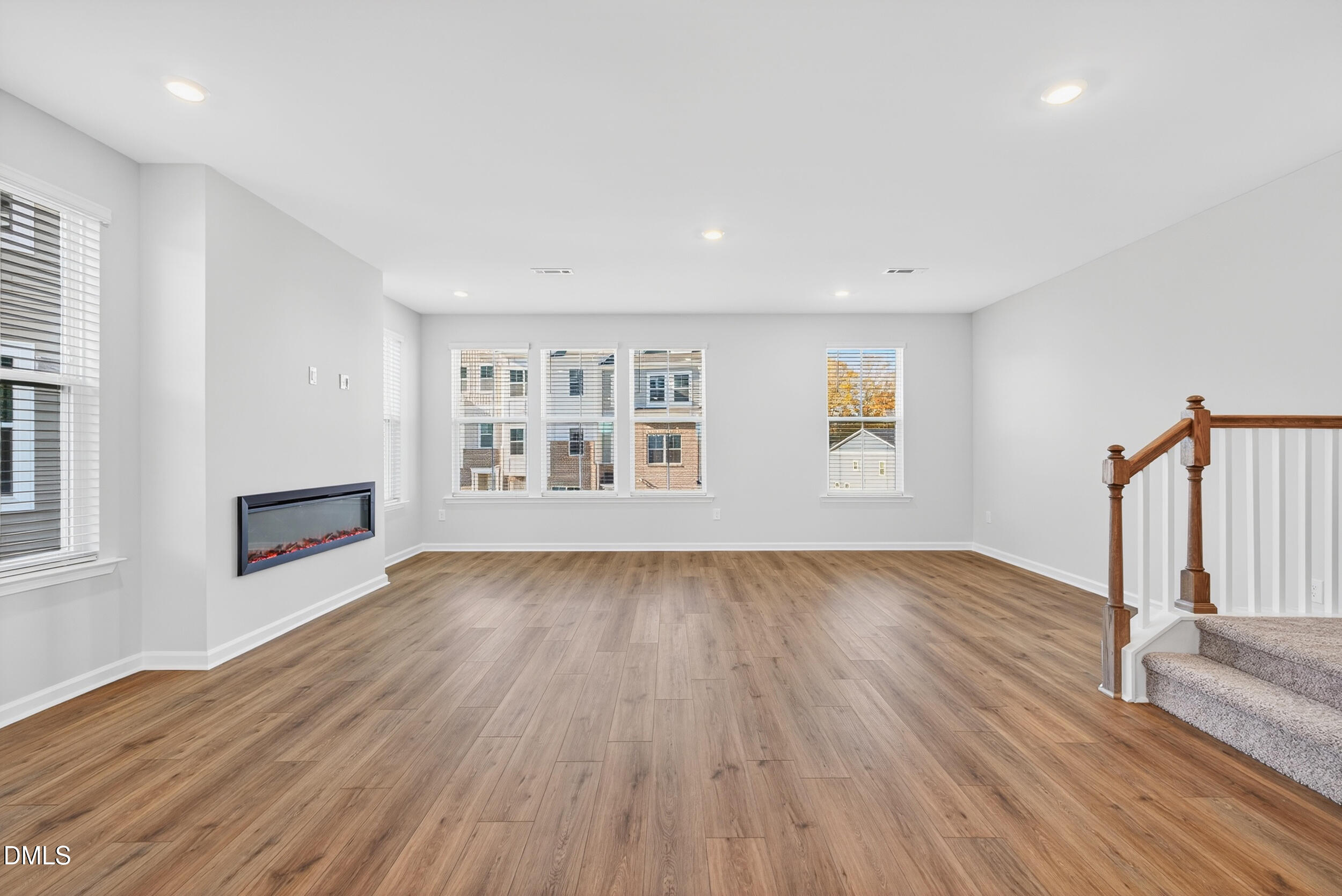 331 Chesapeake Commons Street Garner, NC 27529 - Photo 8 of 20 a view of an empty room with wooden floor and a window
