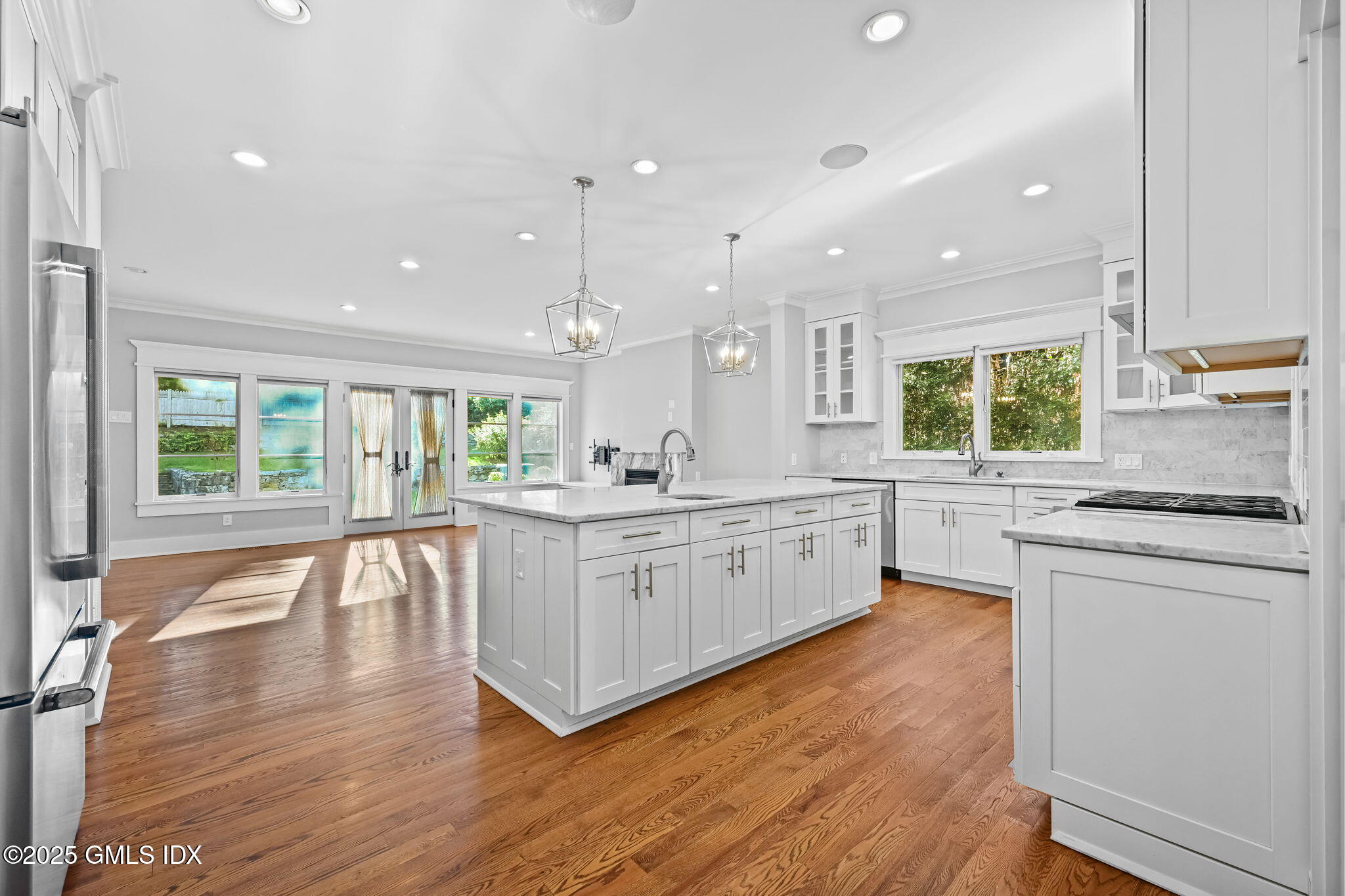 12 Old Wagon Road Old Greenwich, CT 06870 - Photo 20 of 57 a kitchen with stainless steel appliances granite countertop wooden floors and white cabinets