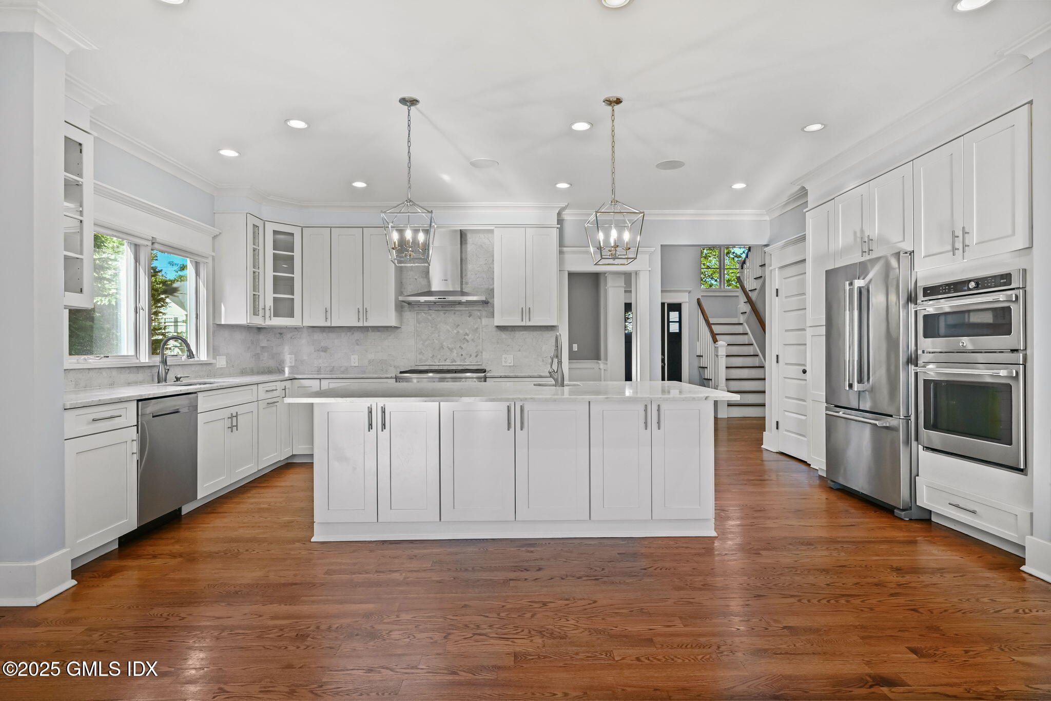 12 Old Wagon Road Old Greenwich, CT 06870 - Photo 23 of 57 a large kitchen with stainless steel appliances kitchen island granite countertop a stove a sink a refrigerator and white cabinets with wooden floor