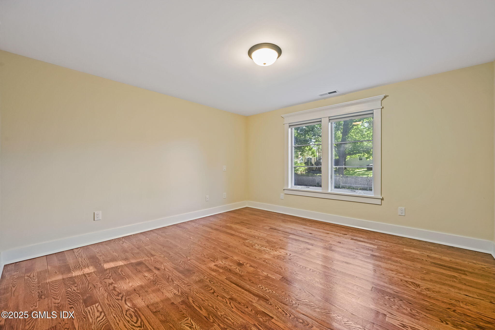 12 Old Wagon Road Old Greenwich, CT 06870 - Photo 50 of 57 a view of an empty room with wooden floor and a window