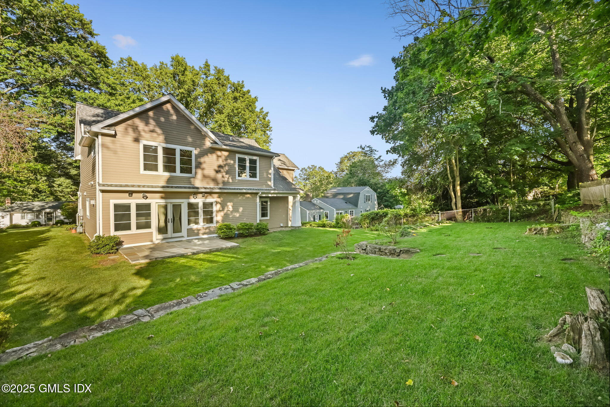 12 Old Wagon Road Old Greenwich, CT 06870 - Photo 55 of 57 a front view of a house with a yard table and chairs