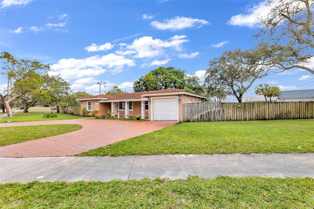 5912 Tyler Street Hollywood, FL 33021 - Photo 9 of 17 a front view of a house with a garden and yard
