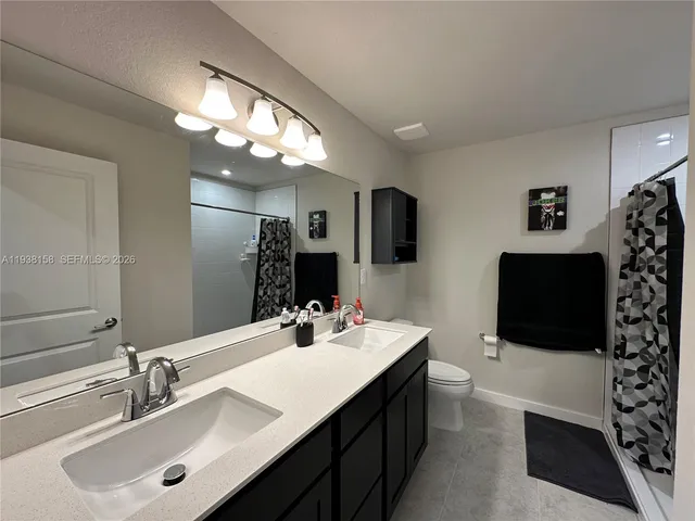 a bathroom with a double vanity sink a mirror and shower