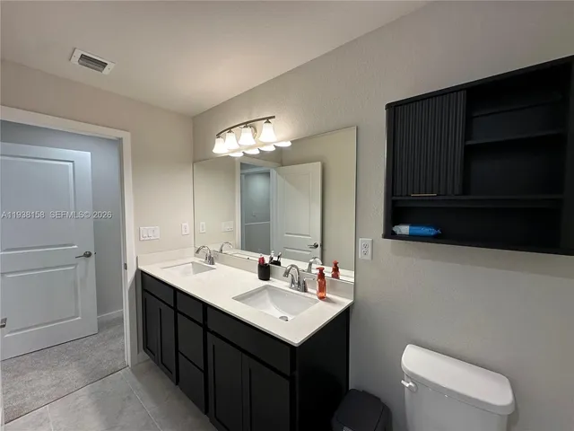 a bathroom with a sink a toilet and mirror