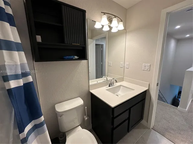 a bathroom with a sink a toilet a mirror and vanity