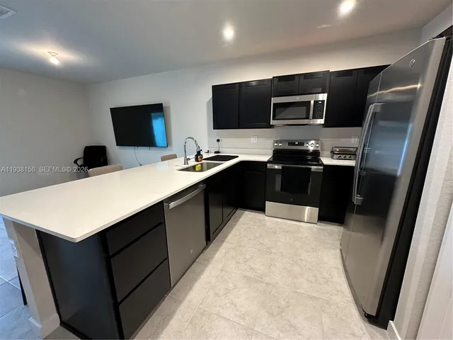a kitchen with a sink appliances and cabinets