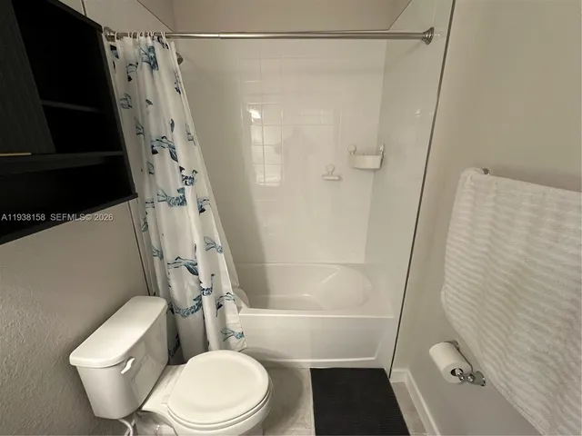 a white toilet sitting next to a bath tub