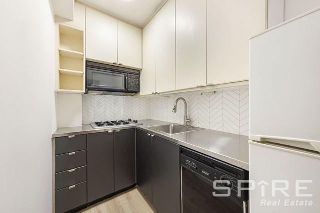 Undisclosed Address Manhattan, NY 10019 - Photo 14 of 20 a kitchen with a sink and cabinets