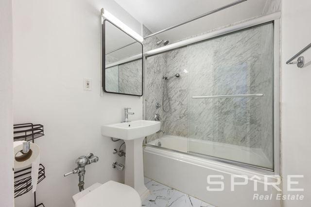Undisclosed Address Manhattan, NY 10019 - Photo 16 of 20 a bathroom with a sink toilet and shower