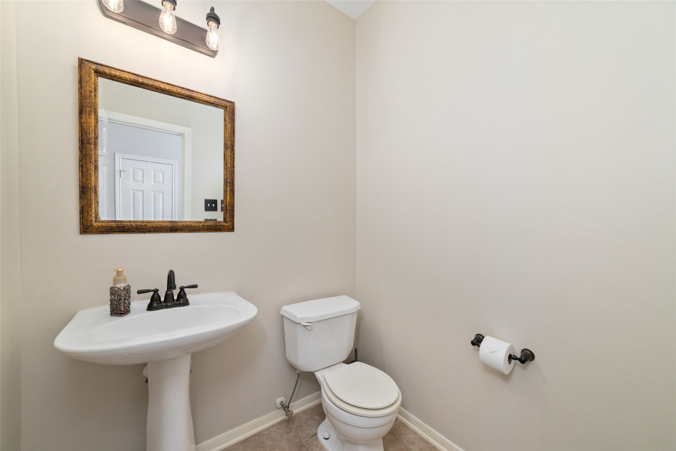 20423 Forest Drive Spring, TX 77388 - Photo 27 of 44 Half bath featuring modern updates, including contemporary lighting fixtures, a stylish vanity mirror, and an upgraded faucet.