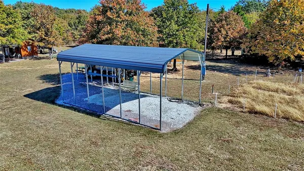 a backyard of a house with barbeque oven and trees