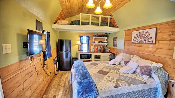 a bedroom with a bed next to a window with kitchen view