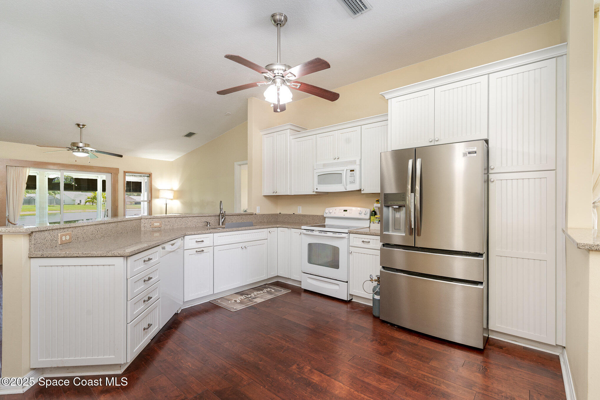 3623 Egret Drive Melbourne, FL 32901 - Photo 3 of 25 a kitchen with white cabinets and stainless steel appliances