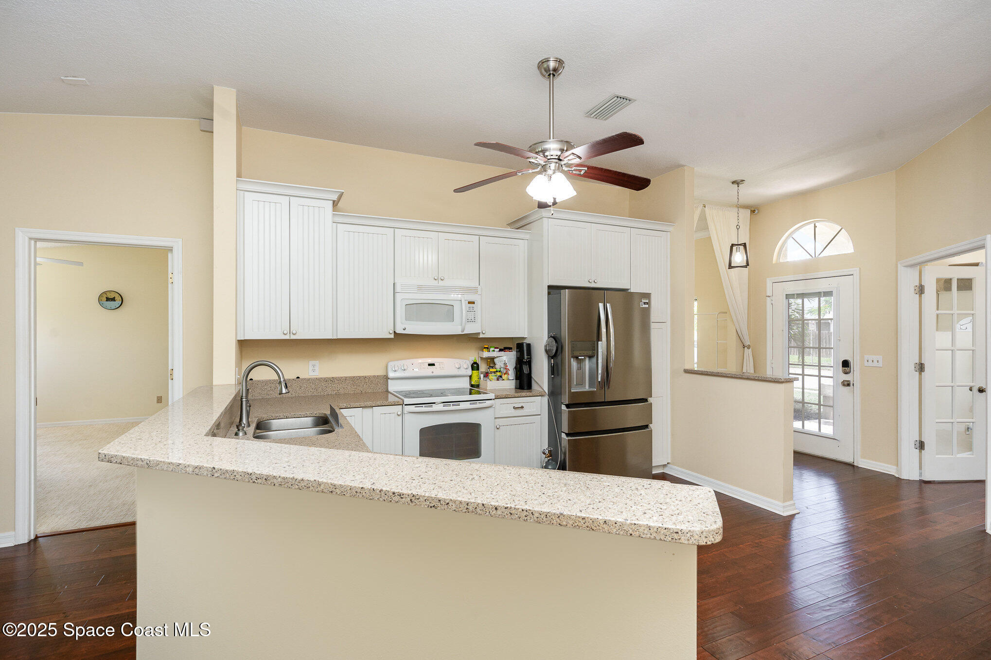 3623 Egret Drive Melbourne, FL 32901 - Photo 4 of 25 a kitchen with refrigerator cabinets and wooden floor