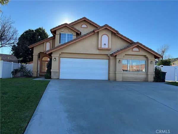 a front view of a house with a garden and garage