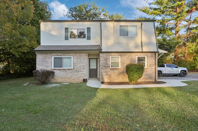 a front view of a house with a garden and yard