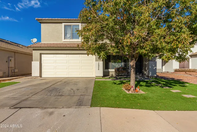 a view of a house with a yard and tree