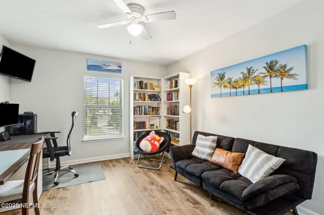 a living room with furniture a flat screen tv and a window