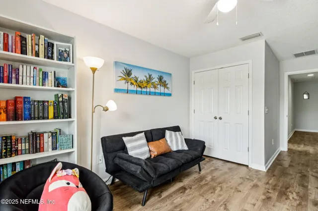a living room with furniture and a book shelf