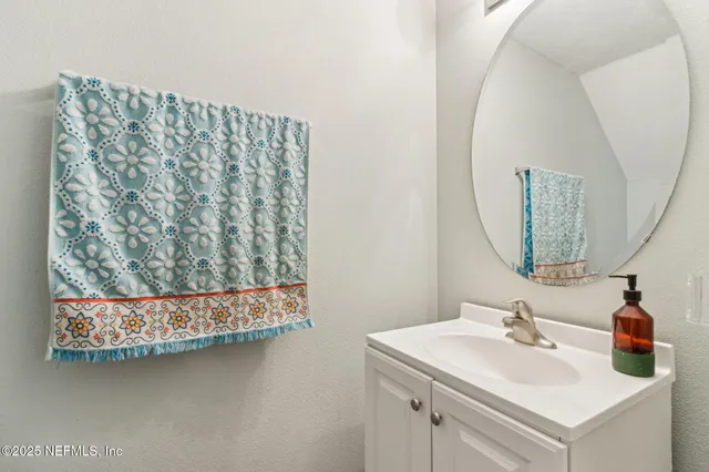 a bathroom with a sink vanity and a mirror