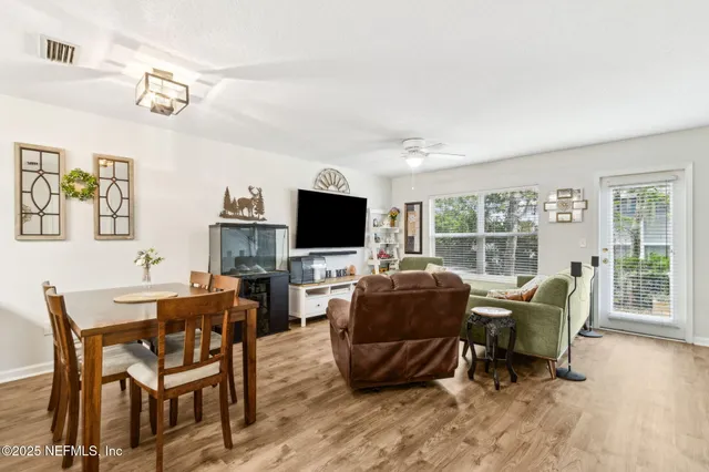 a living room with furniture a flat screen tv and a large window