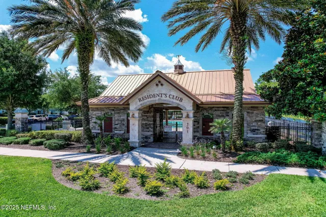 a view of a house with a yard and potted plants