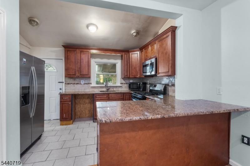 136 Smith Street Elizabeth, NJ 07201 - Photo 9 of 38 a kitchen with stainless steel appliances granite countertop a sink refrigerator and microwave