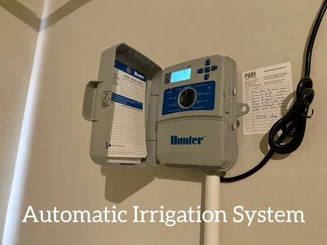 a sign of golf club on a wall under a tree