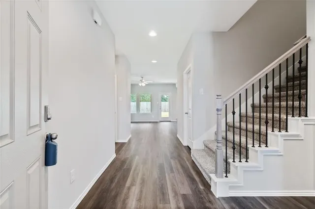 a view of a hallway with wooden floor and staircase