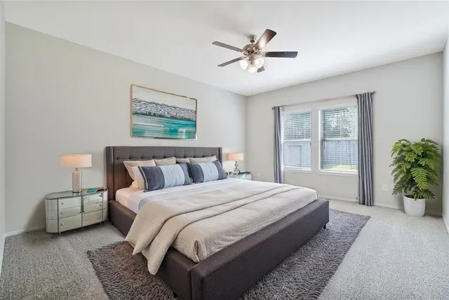 a spacious bedroom with a bed a couch and potted plant