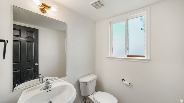 1285 Alpine Way Provo, UT 84606 - Photo 13 of 25 Wall-mounted vanity sink, polished chrome faucet, rectangular mirror, and a two-bulb sconce with brass-finish hardware
