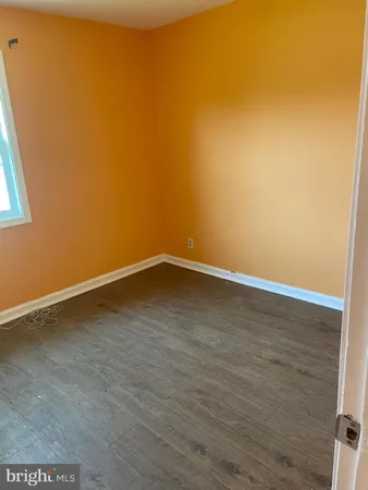 a room with wooden floor and a window