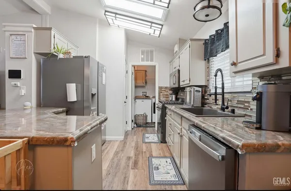 a kitchen with stainless steel appliances granite countertop a sink stove and refrigerator